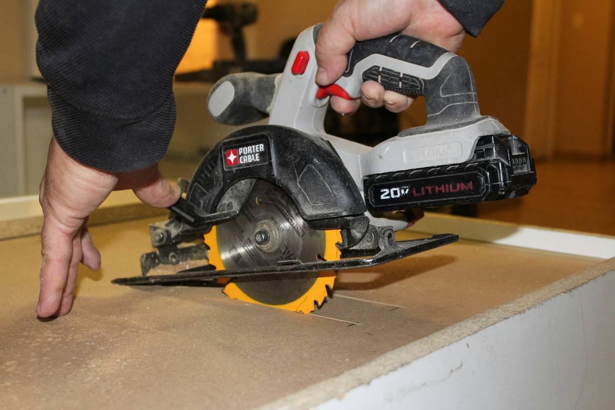 Close-up of random orbital sander for sanding walls showing dust extraction port and pad