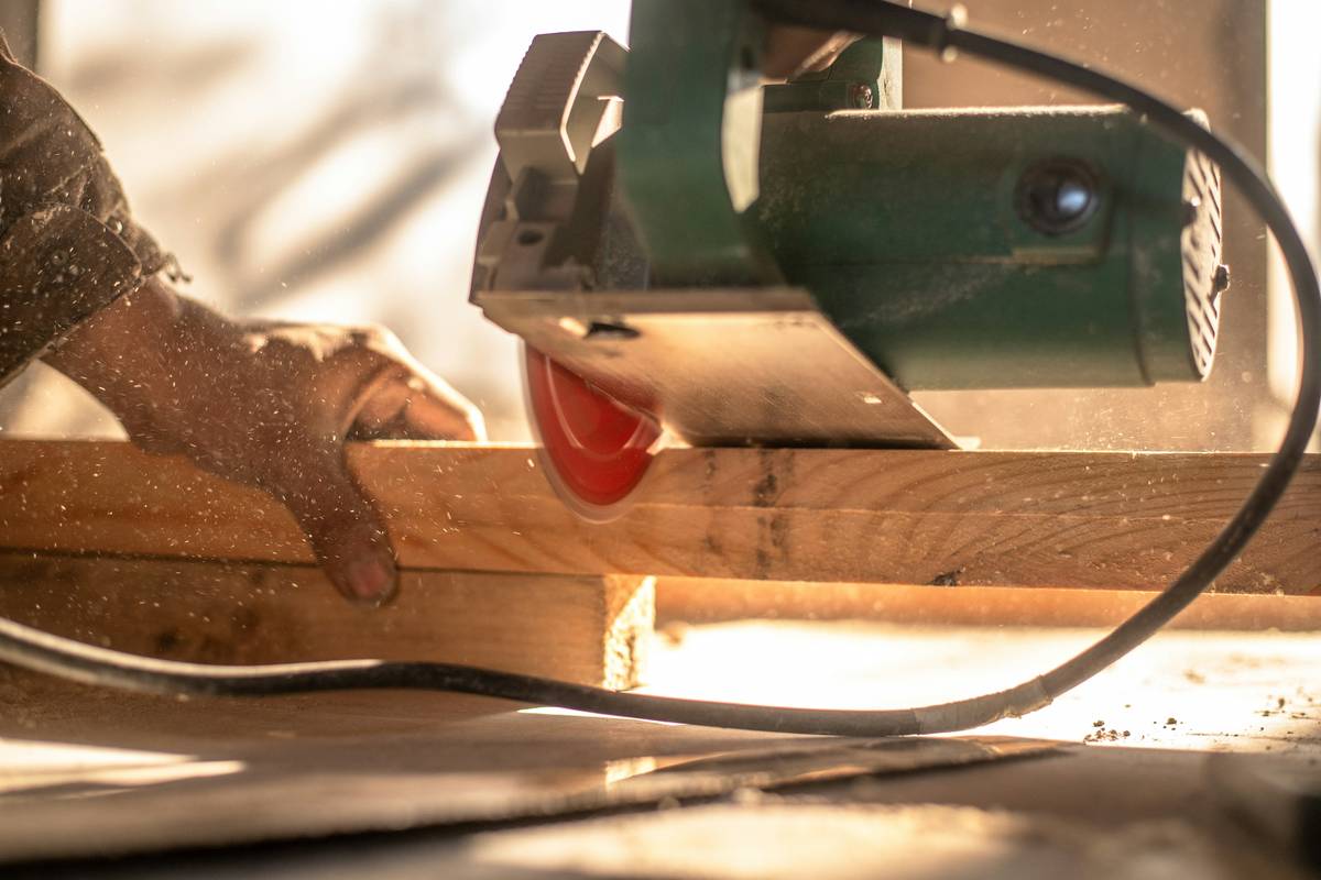 diy random orbital sander in action on wooden table edge showing proper hand position and dust extraction setup